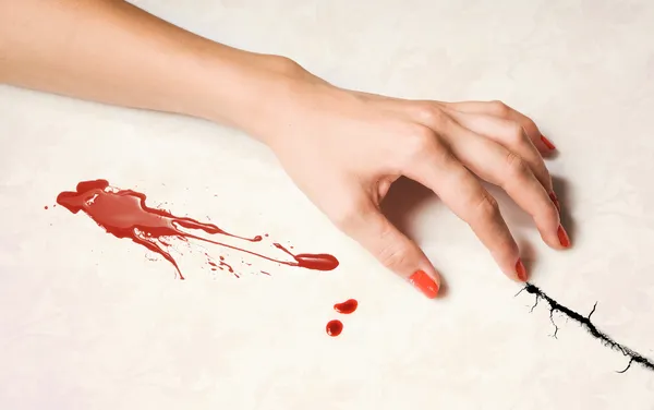 Kvinnans hand och en droppe blod — Stockfoto