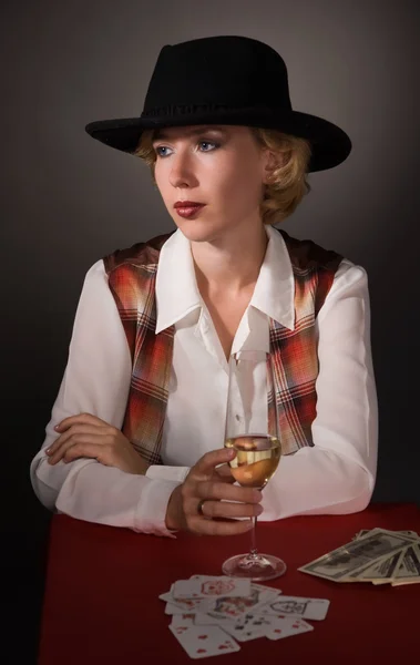 Όμορφη γυναίκα σε ένα μαύρο καπέλο με ένα ποτήρι κρασί — Φωτογραφία Αρχείου