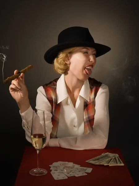 Mooie vrouw in een zwarte hoed met een sigaar — Stockfoto