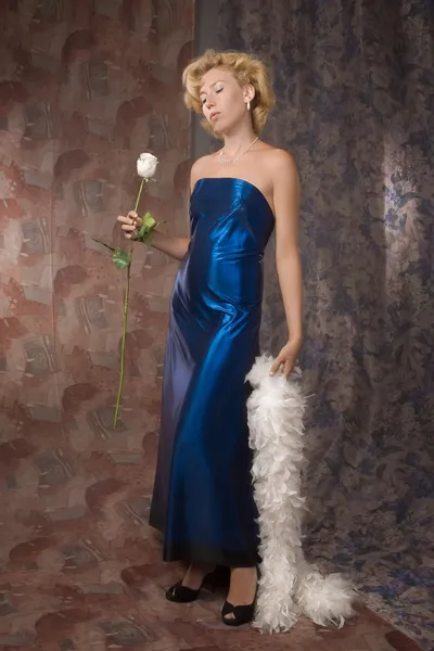 Žena v tmavě modrých šatech s bílou růží — Stock fotografie