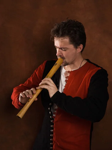 Muž v obleku středověké hraje na flétnu — Stock fotografie