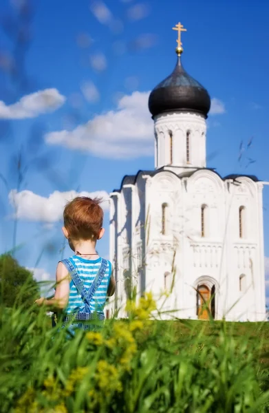 Küçük çocuk bir Ortodoks Kilisesi arka planda — Stok fotoğraf