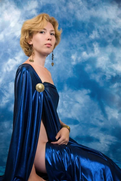 Mooie blonde vrouw in donker blauw stof — Stockfoto
