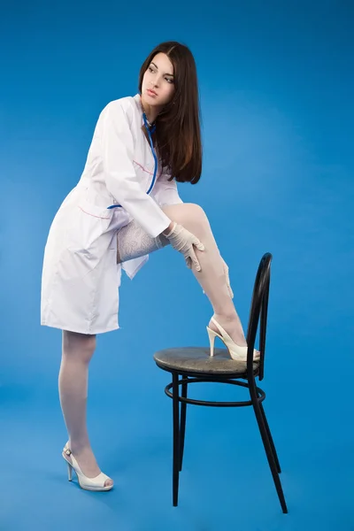 A pretty young nurse straightens stockings — Stock Photo, Image