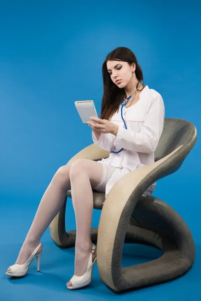 Jonge verpleegster zittend in een stoel — Stockfoto