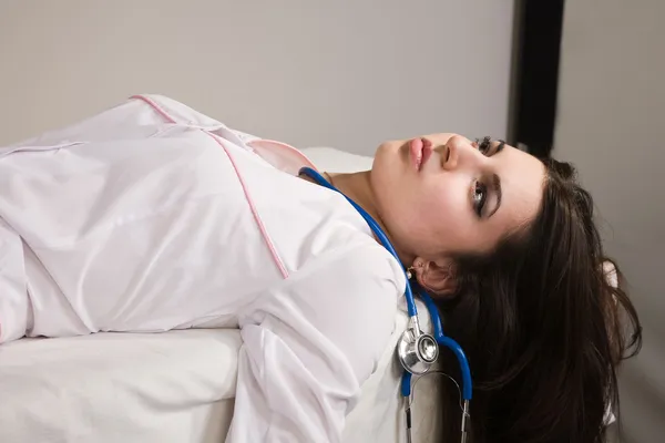 Безжизненная медсестра лежит на диване — стоковое фото