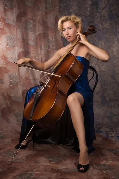 Женщина в вечернем платье играет на виолончели — стоковое фото