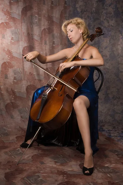 Kvinna i klänning spelar cello — Stockfoto