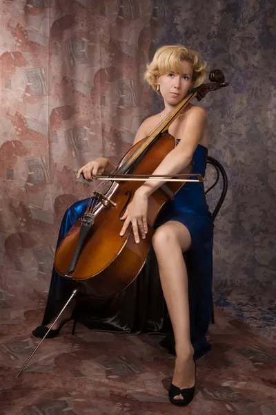 Kvinna i klänning spelar cello — Stockfoto