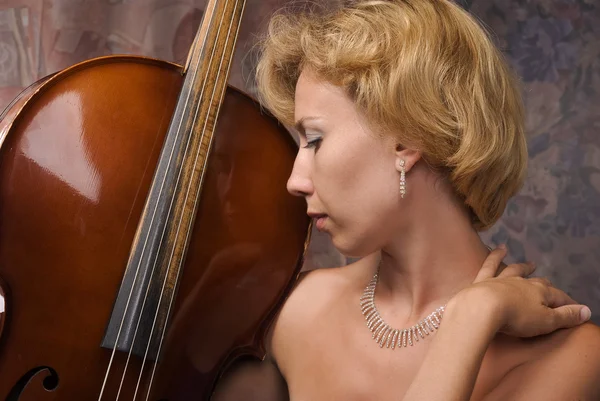 Žena ve večerních šatech pózuje s violoncello — Stock fotografie