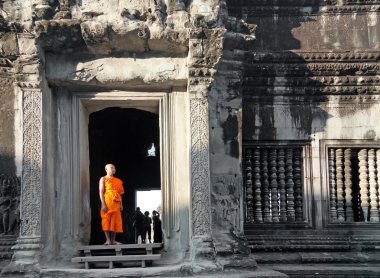 Buddhist monk posing for photographers in Angkor Wat temple clipart