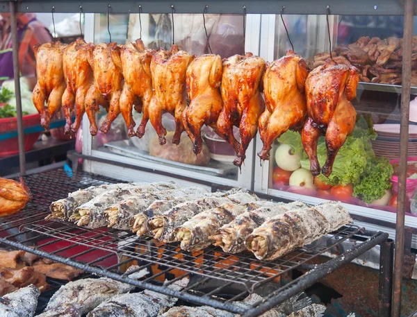 Rangée de poissons grillés et poules sur le marché de rue — Photo