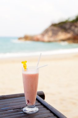 Milk cocktail in glass with ice and straw clipart