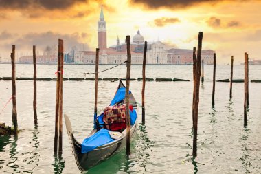 Gondola at sunset pier near in Venice, Italy clipart