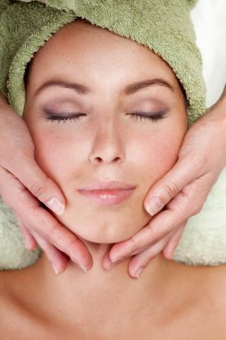 Young woman receiving facial massage clipart
