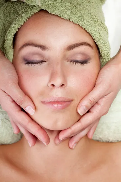 Mladá žena dostává masáž obličeje — Stock fotografie