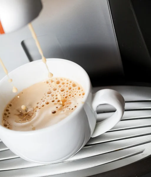 Espresso derramando em uma xícara branca — Fotografia de Stock