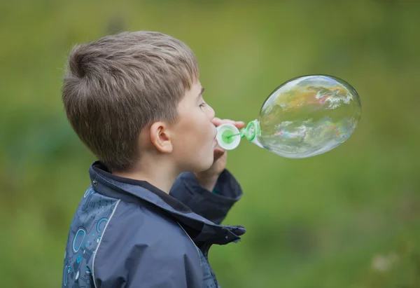 Мальчик запускает мыльные пузыри — стоковое фото
