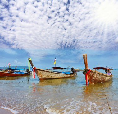 A boats Longtails anchored awaiting passengers clipart