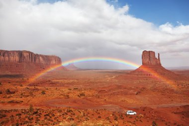 A white car under a rainbow clipart