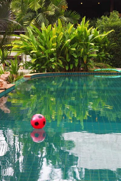 Červený plážový míč plovoucí v bazénu — Stock fotografie