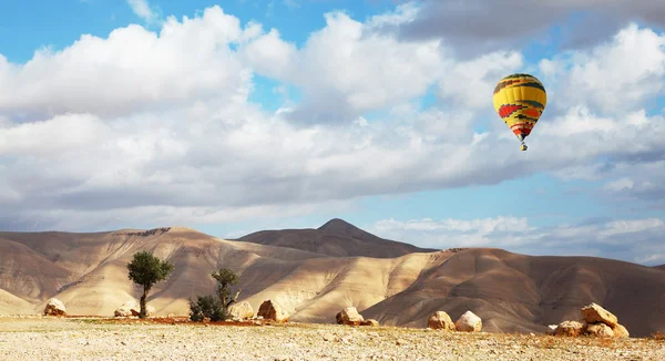Яскрава повітряна куля над м'якими пагорбами — стокове фото