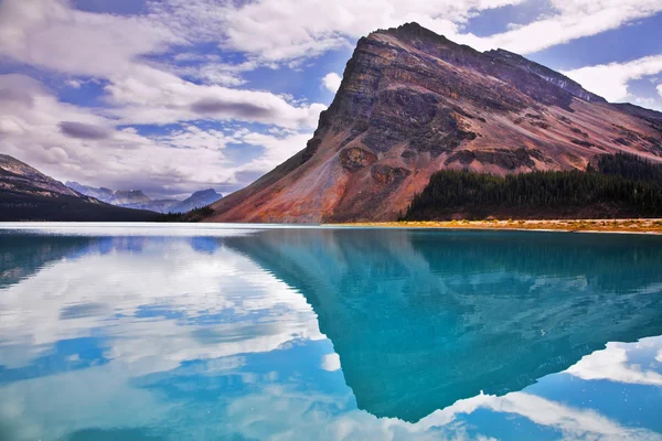Soğuk dağ gölü zümrüt suların büyük kaya — Stok fotoğraf