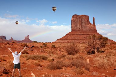 Enthusiastic tourists in Monument Valley and colorful balloons clipart