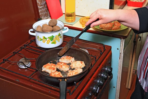 Frau frittiert Koteletts auf schwarzem Grill — Stockfoto