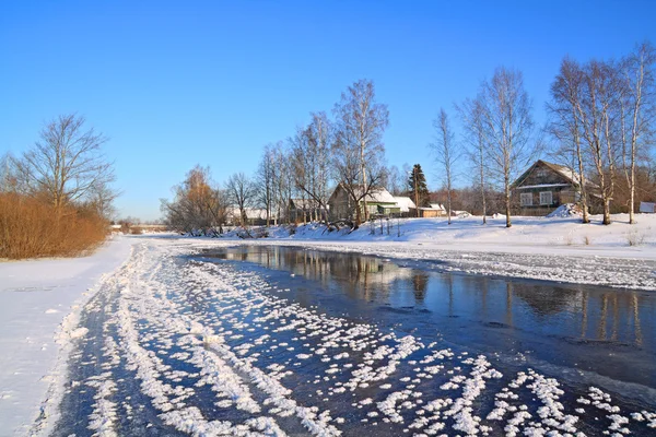 Villaggio invernale sul fiume costa — Foto Stock