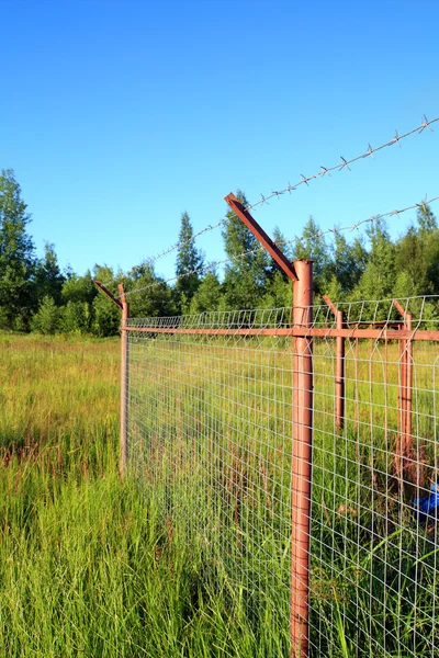 Fence on green field — Stock Photo, Image