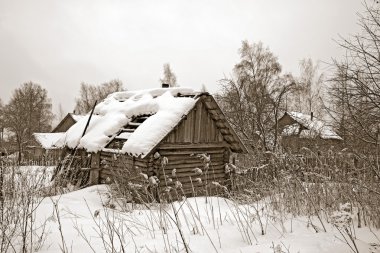 Old wooden house amongst winter snow clipart