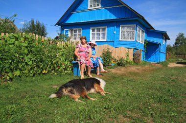 Two womens with dog in rural courtyard