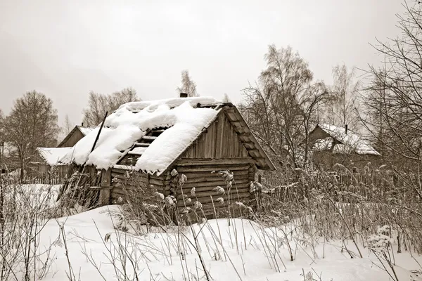 Old wooden house amongst winter snow — Stok fotoğraf