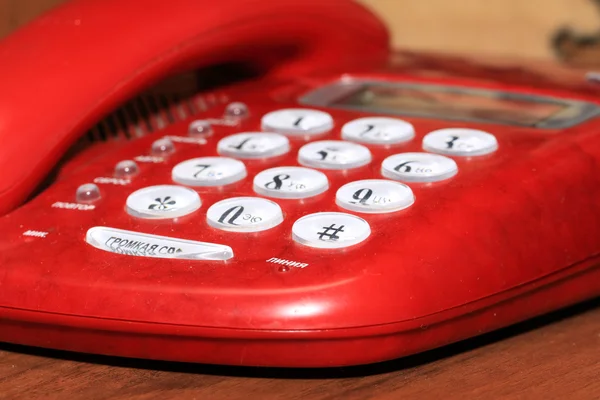 Old red telephone on wooden table — Stock Photo, Image