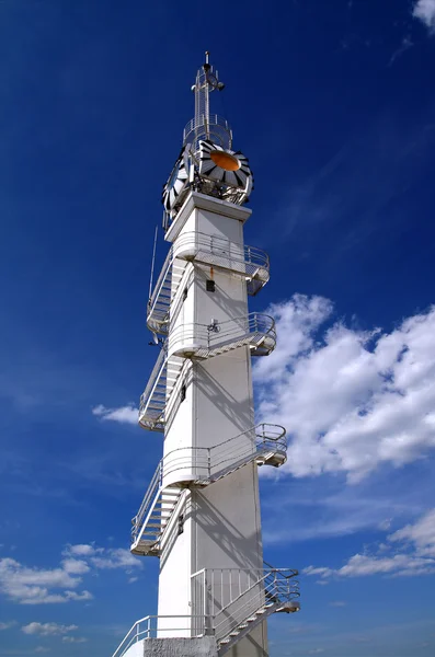 Білий маяк на хмарному фоні — стокове фото