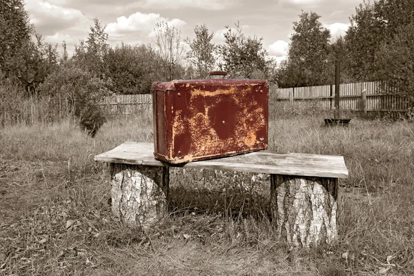 Starý kufr poblíž dřevěné lavice, Sepie — Stock fotografie