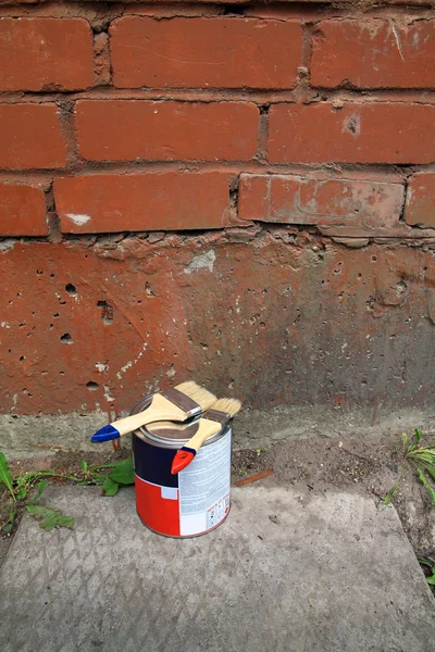 Kirli duvarının yakınında yeni boya fırçası — Stok fotoğraf