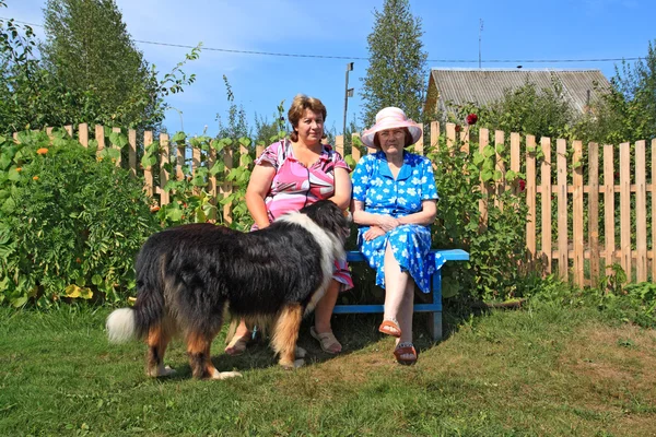 Duas mulheres com cão no pátio rural — Fotografia de Stock