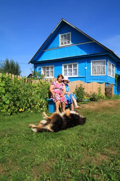 Dos mujeres con perro cerca de edificio rural — Foto de Stock