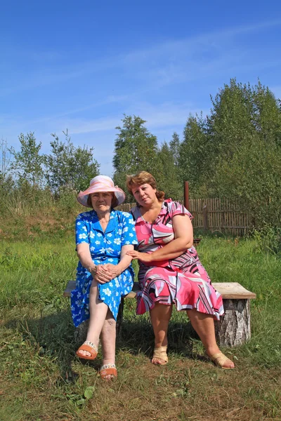 Duas mulheres no banco de madeira — Fotografia de Stock