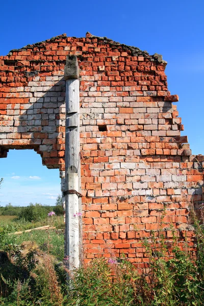 Red brick destroyed building amongst green herb — Stockfoto