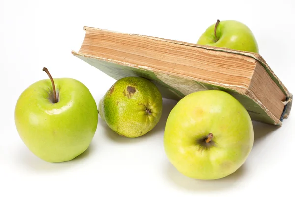 Äpplen och gammal bok — Stockfoto