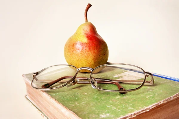 Pear, very old book and old glasses — Stock Photo, Image