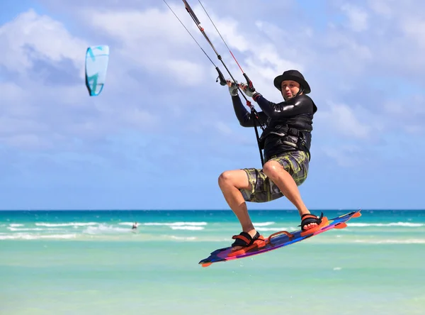 Mann im Flug über Wasser. Kitesurfen an der kubanischen Küste. — Stockfoto