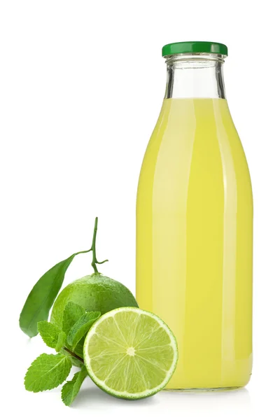 Limettensaftflasche, reife Limetten und Minze — Stockfoto