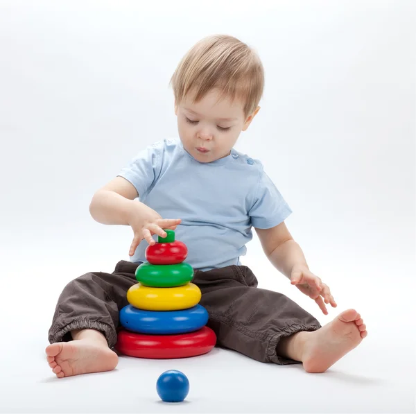 Kleines Baby mit einer Spielzeugpyramide — Stockfoto