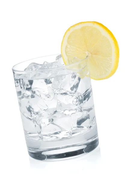 Стакан чистой воды с кубиками льда и ломтиками лимона — стоковое фото