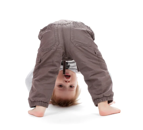 Small baby stands on head — Stock Photo, Image