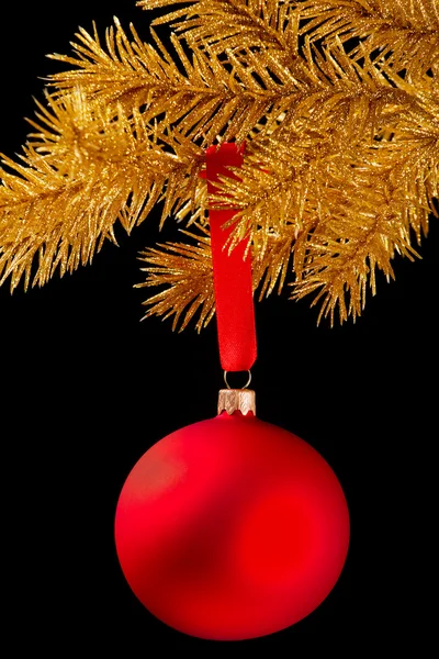 Palla di Natale rossa su un nastro contro sfondo nero — Foto Stock
